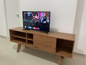 a flat screen tv sitting on top of a wooden entertainment center at Ap alto padrão a 50m do sobral shopping in Sobral