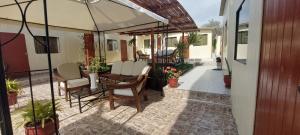 une terrasse avec une table, des chaises et un parasol dans l'établissement R. A. C. S., à Paracas