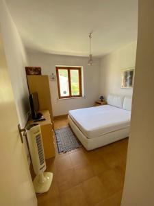 a bedroom with a white bed and a television at Appartamento in Residence Mareblu in Nocera Terinese