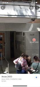 a picture of two people sitting in front of a building at Cómodo dos ambientes in Buenos Aires