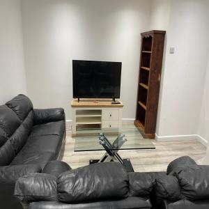 a living room with a couch and a flat screen tv at Bethel Apartments in Leeds