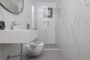 a white bathroom with a toilet and a sink at 777 Studios Corfu in Agios Ioannis