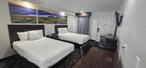 um quarto de hotel com duas camas e uma televisão em Days Inn by Wyndham Indianapolis East Post Road em Indianápolis