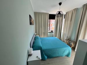 Schlafzimmer mit einem blauen Bett und einem Tisch in der Unterkunft Affittacamere L'Aurora in Zagarolo