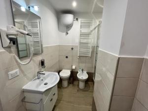 a white bathroom with a sink and a toilet at Affittacamere L'Aurora in Zagarolo