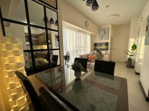 una sala da pranzo e un soggiorno con tavolo e sedie. di Celandine Residence in Quezon City a Manila