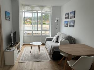 a living room with a couch and a table at Apartamento paseo marítimo Camelle in Camelle