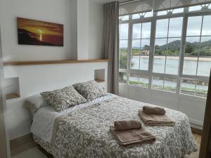 a bedroom with a bed with two towels on it at Apartamento paseo marítimo Camelle in Camelle