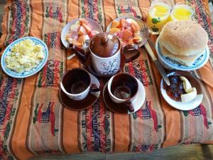 a table with a breakfast of coffee and a hamburger and eggs at Jhonyximena in Copacabana