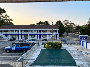 a blue building with a tennis court in front of it at Point Pleasant Inn in Point Pleasant Beach