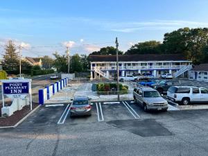 a parking lot with cars parked in front of a building at Point Pleasant Inn in Point Pleasant Beach