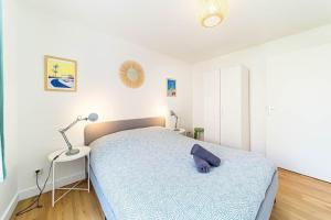 Un dormitorio con una cama con una manta azul. en Le Marcellin charmant 6 pers Sainte-Foy-lès-Lyon en Sainte-Foy-lès-Lyon