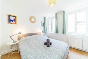 um quarto com uma cama, um candeeiro e janelas em Le Marcellin charmant 6 pers Sainte-Foy-lès-Lyon em Sainte-Foy-lès-Lyon