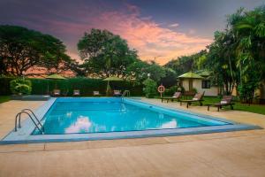 una piscina en un patio con puesta de sol en Ramada Katunayake en Katunayaka
