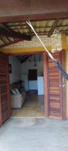 a living room with a couch and a room with doors at Vila Flamboyant in Barra Grande