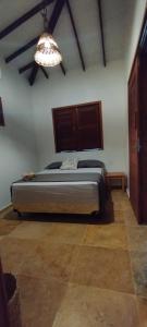 um quarto com uma cama e um lustre em Vila Flamboyant em Barra Grande