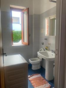 a bathroom with a sink and a toilet and a window at Appartamento in Residence Mareblu in Nocera Terinese