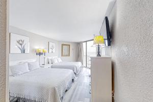 een witte kamer met 2 bedden en een bank bij Sands Ocean Club 1630 in Myrtle Beach