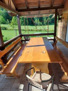 a wooden table and a chair on a patio at Holiday house with a parking space Otocac, Velebit - 19973 in Otočac