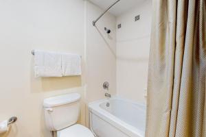 a white bathroom with a toilet and a shower at Luau, Unit 6108 in Destin