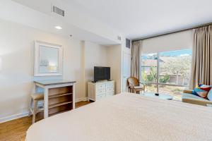 a bedroom with a bed and a desk and a window at Luau, Unit 6108 in Destin