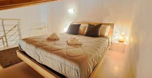 ein Schlafzimmer mit einem großen Bett mit Handtüchern darauf in der Unterkunft CASA DI GIULIA con soggiorno e cucina, camera matrimoniale con tetto a vista e grande parco circostante in Serravalle dʼAsti