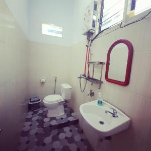 een badkamer met een wit toilet en een wastafel bij The Sanduk Homestay in Rantepao