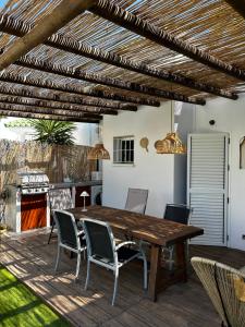 un patio con mesa de madera y sillas en Casita Mar de Pulpí, en San Juan de los Terreros