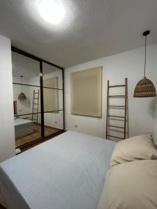 1 dormitorio con cama, escalera y espejo en Casita Mar de Pulpí, en San Juan de los Terreros