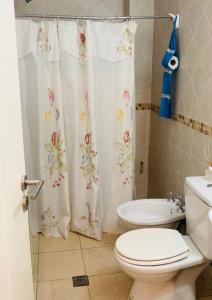 a bathroom with a toilet and a shower curtain at Cerca de todo! Ubicación estratégica in Godoy Cruz