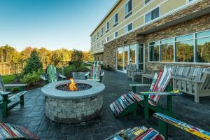 a patio with chairs and a fire pit in front of a building at Fairfield Inn & Suites by Marriott Plymouth White Mountains in Plymouth