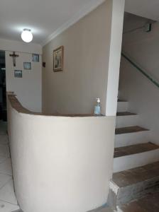Una escalera blanca en un edificio con una botella. en Pousada Videiras Santa Rita de Cássia, en Cachoeira Paulista