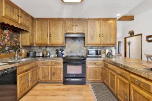 cocina con armarios de madera y horno con fogones en 2330-Maple Leaf Retreat chalet, en Big Bear City