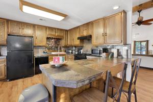 cocina con armarios de madera y nevera negra en 2330-Maple Leaf Retreat chalet, en Big Bear City