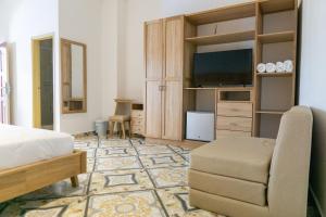 a bedroom with a bed and a tv and a chair at Hotel Abitti in Taganga