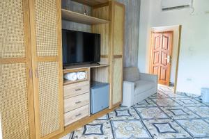 a living room with a entertainment center with a flat screen tv at Hotel Abitti in Taganga