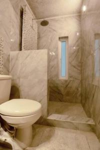 baño con aseo y ducha con ventana en DICI Coliving Housing The Friends Room, en Cabo San Lucas