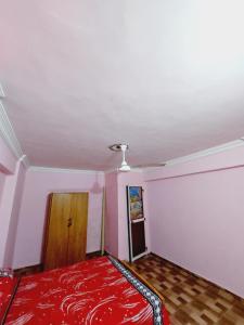 Cette chambre dispose d'un lit rouge et d'un plafond. dans l'établissement شقة مفروشة مجهزة بشارع خالد بن الوليد بالإسكندرية مصر, à Alexandrie