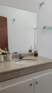 La salle de bains est pourvue d'un lavabo et d'un miroir. dans l'établissement Casa da Fé, à Cachoeira Paulista