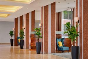 een lobby met stoelen en potplanten in een gebouw bij Sheraton Skyline Hotel London Heathrow in Hillingdon