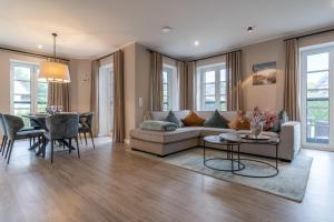 a living room with a couch and a table at Summer Diek Reetdachhaus Summerdiek 9 in Sankt Peter-Ording