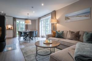 ein Wohnzimmer mit Sofa und Tisch in der Unterkunft Summer Diek Ferienhaus Summerdiek 7 in Sankt Peter-Ording