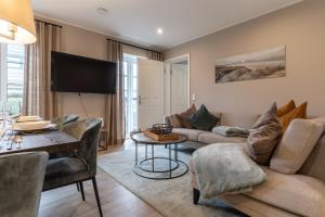 a living room with a couch and a table at Summer Diek Reetdachhaus Summerdiek 11 in Sankt Peter-Ording
