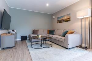 ein Wohnzimmer mit Sofa und Tisch in der Unterkunft Summer Diek Ferienhaus Summerdiek 8 in Sankt Peter-Ording