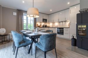 eine Küche und ein Esszimmer mit Tisch und Stühlen in der Unterkunft Summer Diek Ferienhaus Summerdiek 8 in Sankt Peter-Ording