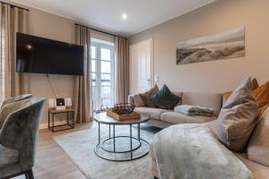 a living room with a couch and a table at Summer Diek Reetdachhaus Summerdiek 10 in Sankt Peter-Ording