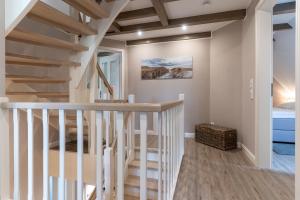 a staircase in a home with wooden ceilings at Summer Diek Reetdachhaus Summerdiek 10 in Sankt Peter-Ording