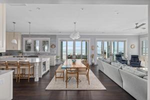 a kitchen and living room with a table and a couch at Beachfront Pool Outdoor Kitchen Firepit Putting Green in Folly Beach