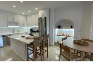 a kitchen with a table and chairs and a refrigerator at Seaside Luxury Komi Beach Villa in Kómi