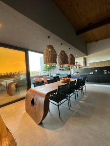 a dining room with a large wooden table and chairs at Cobertura Milagres do Chef in São Miguel dos Milagres